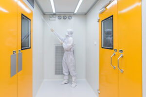 A scientist in sterile coverall gown using Cleaning tool for cle